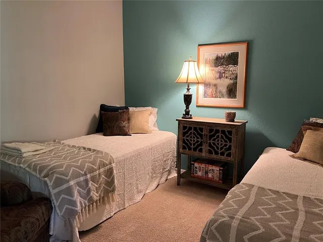 a bedroom with a bed a dresser and a window
