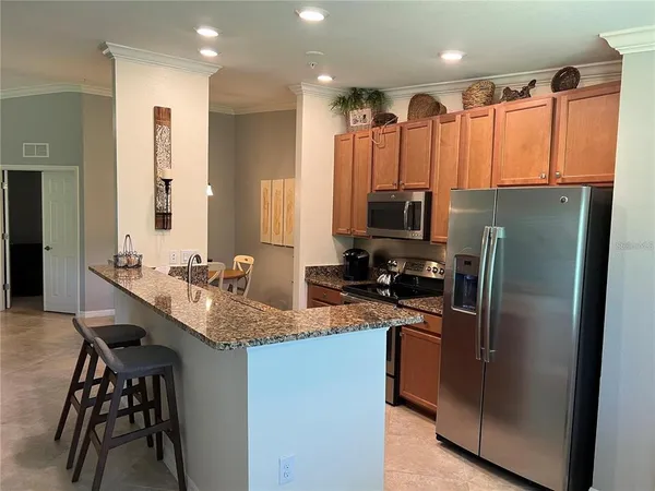 a kitchen with stainless steel appliances granite countertop a refrigerator a stove and a sink