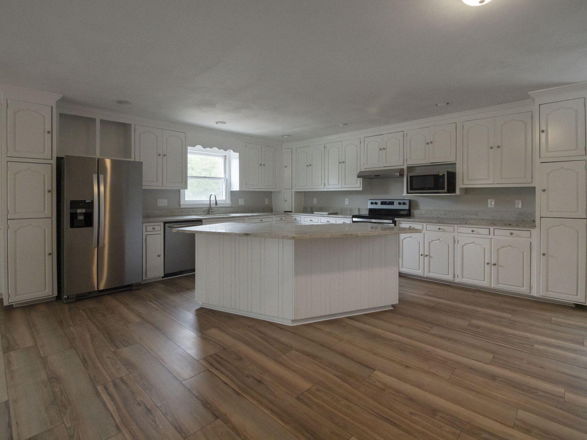 2665 Iron Ridge Road Rocky Mount, VA 24151 - Photo 5 of 26 a kitchen with stainless steel appliances granite countertop a stove top oven a refrigerator a sink and dishwasher with wooden floors
