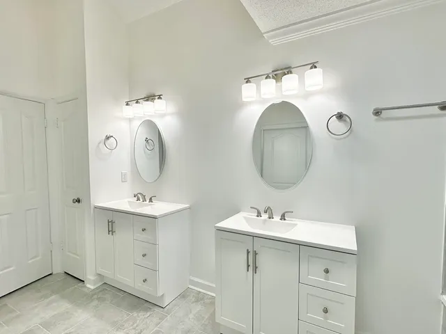 a bathroom with a double vanity sink mirror and