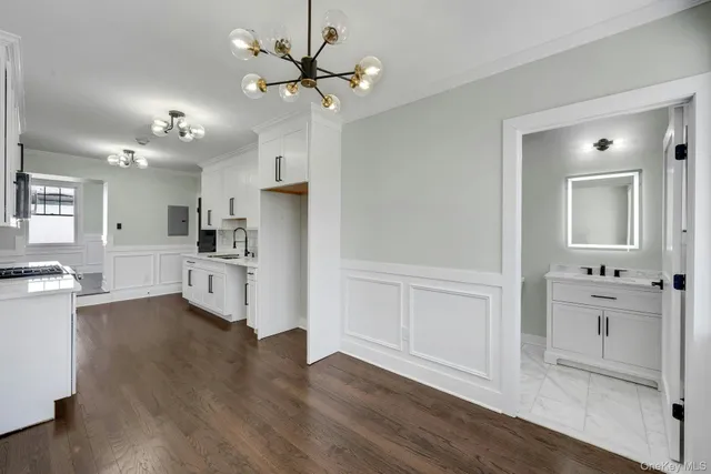 a view of kitchen with wooden floor and electronic appliances