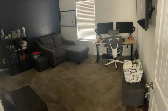 a living room with furniture a flat screen tv and a window