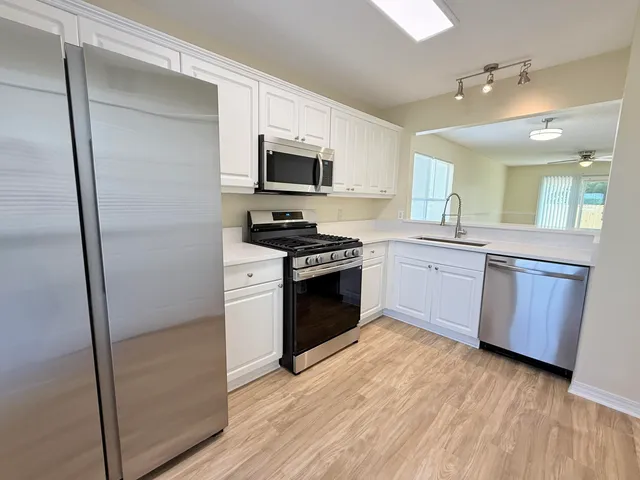 a kitchen with stainless steel appliances a stove a sink and a refrigerator