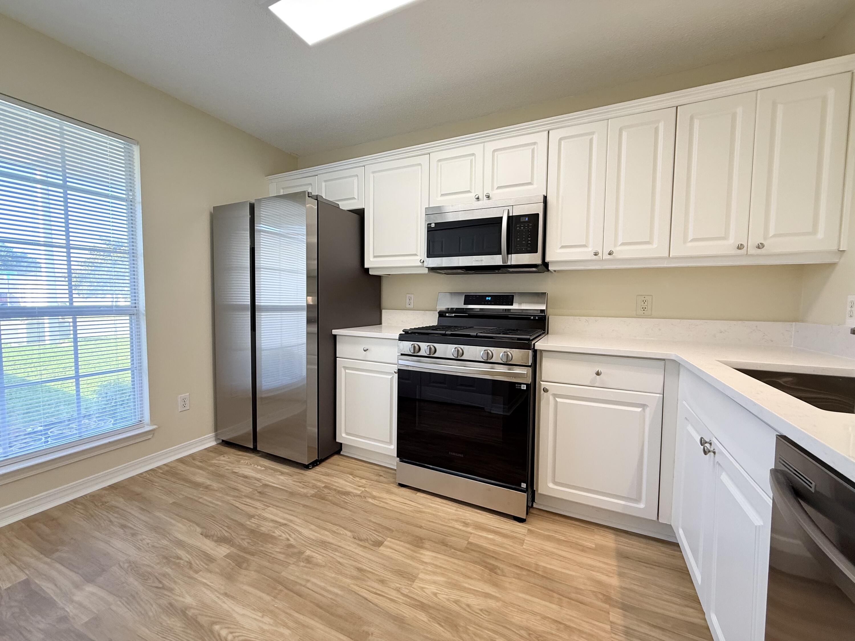 7612 Chablis Circle Navarre, FL 32566 - Photo 3 of 16 a kitchen with stainless steel appliances granite countertop a stove a sink and a refrigerator