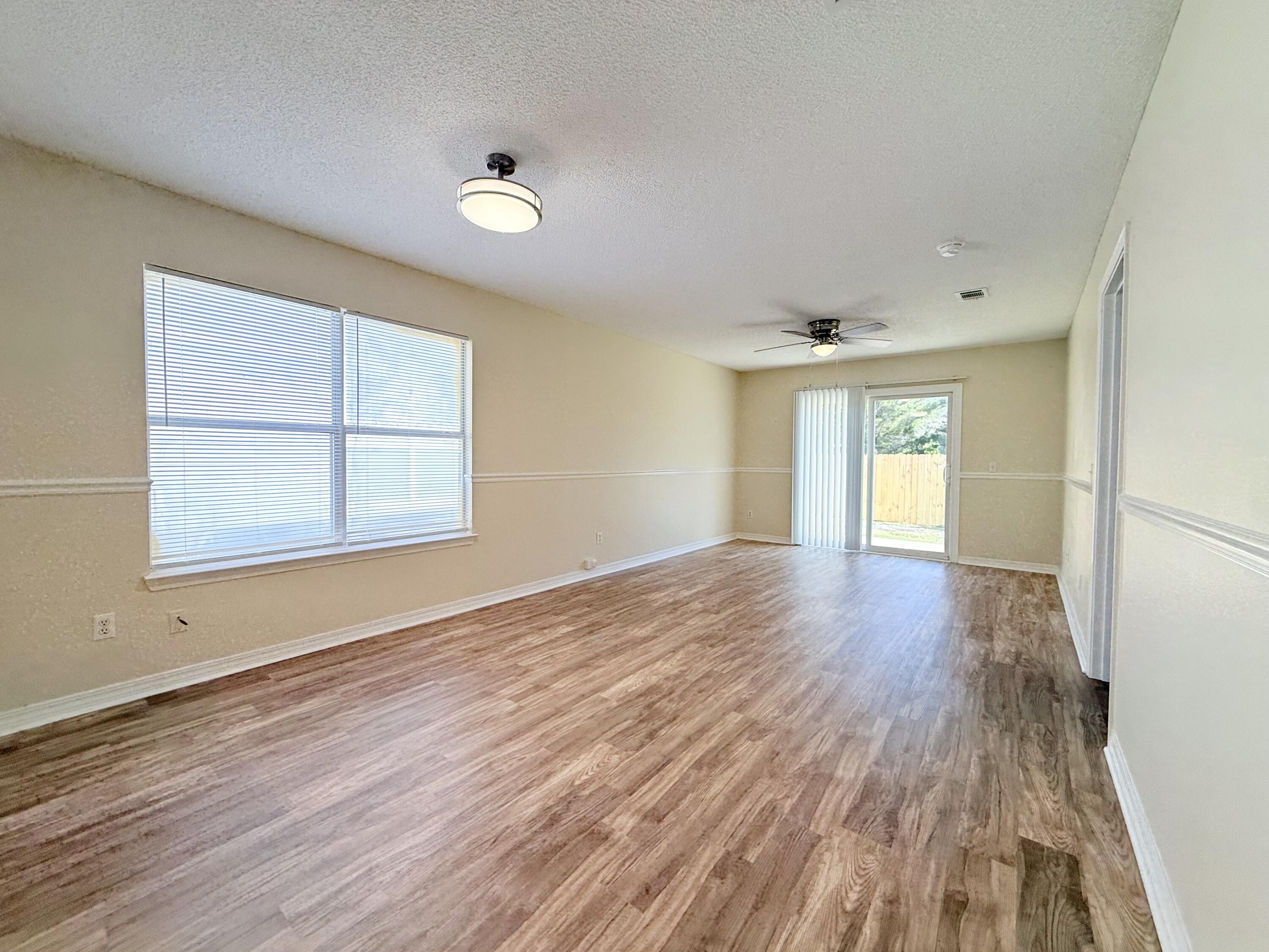 7612 Chablis Circle Navarre, FL 32566 - Photo 6 of 16 a view of empty room with wooden floor and fan