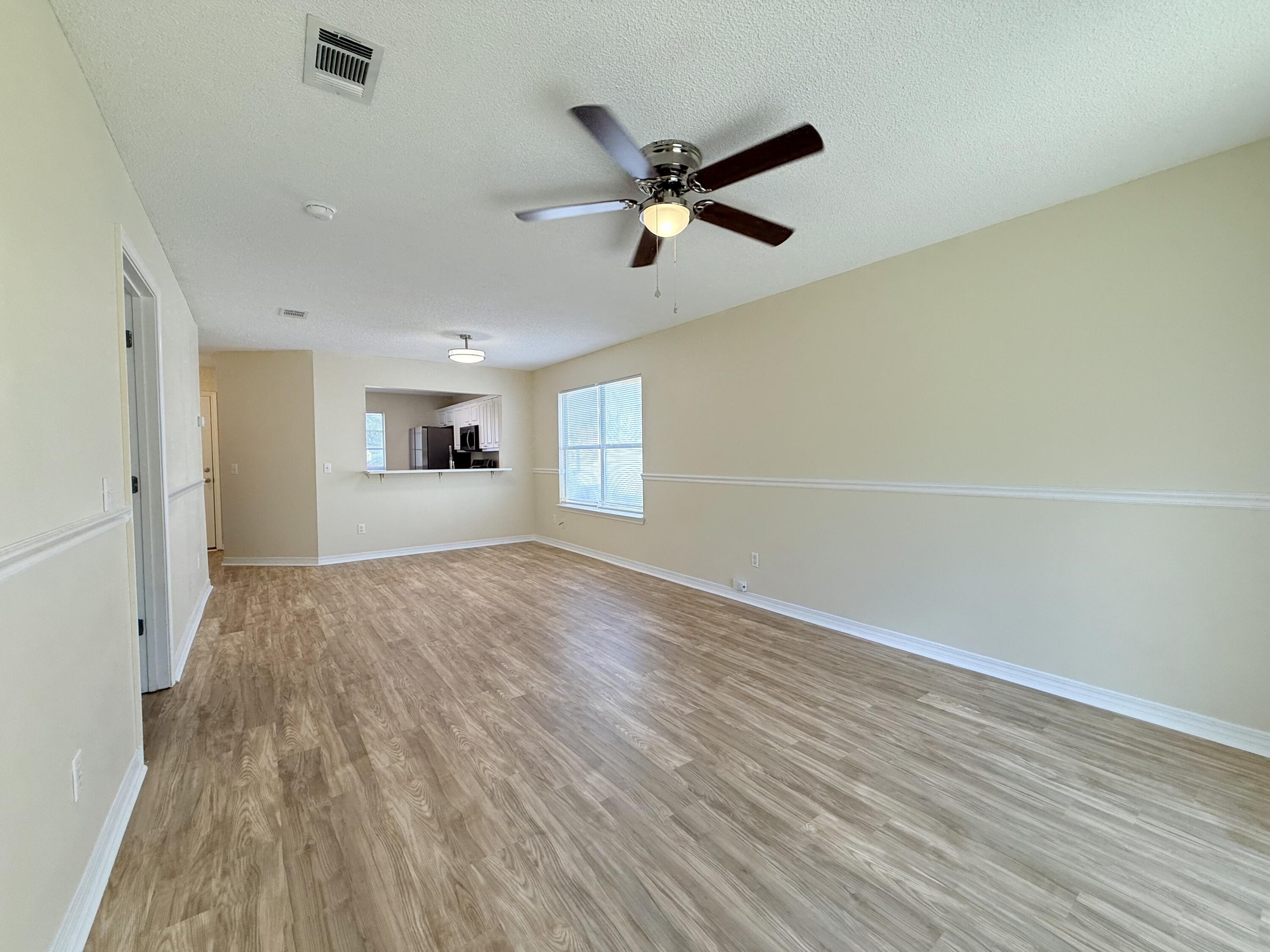 7612 Chablis Circle Navarre, FL 32566 - Photo 7 of 16 wooden floor in an empty room with a window