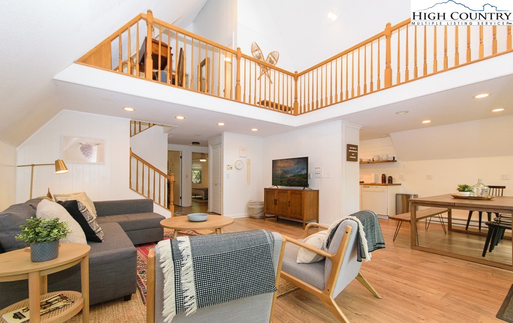 a living room with furniture a flat screen tv and windows