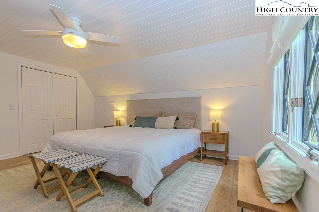 205 Spring Branch Road Beech Mountain, NC 28604 - Photo 19 of 46 a bedroom with a bed and a chandelier