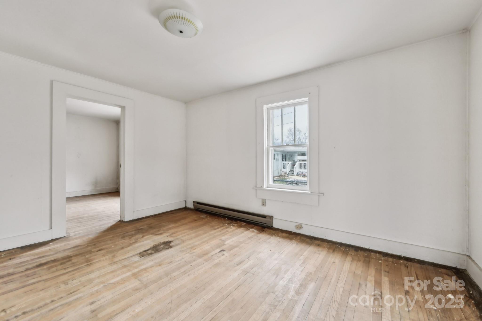 364 Browning Road Waynesville, NC 28786 - Photo 23 of 29 an empty room with wooden floor and windows