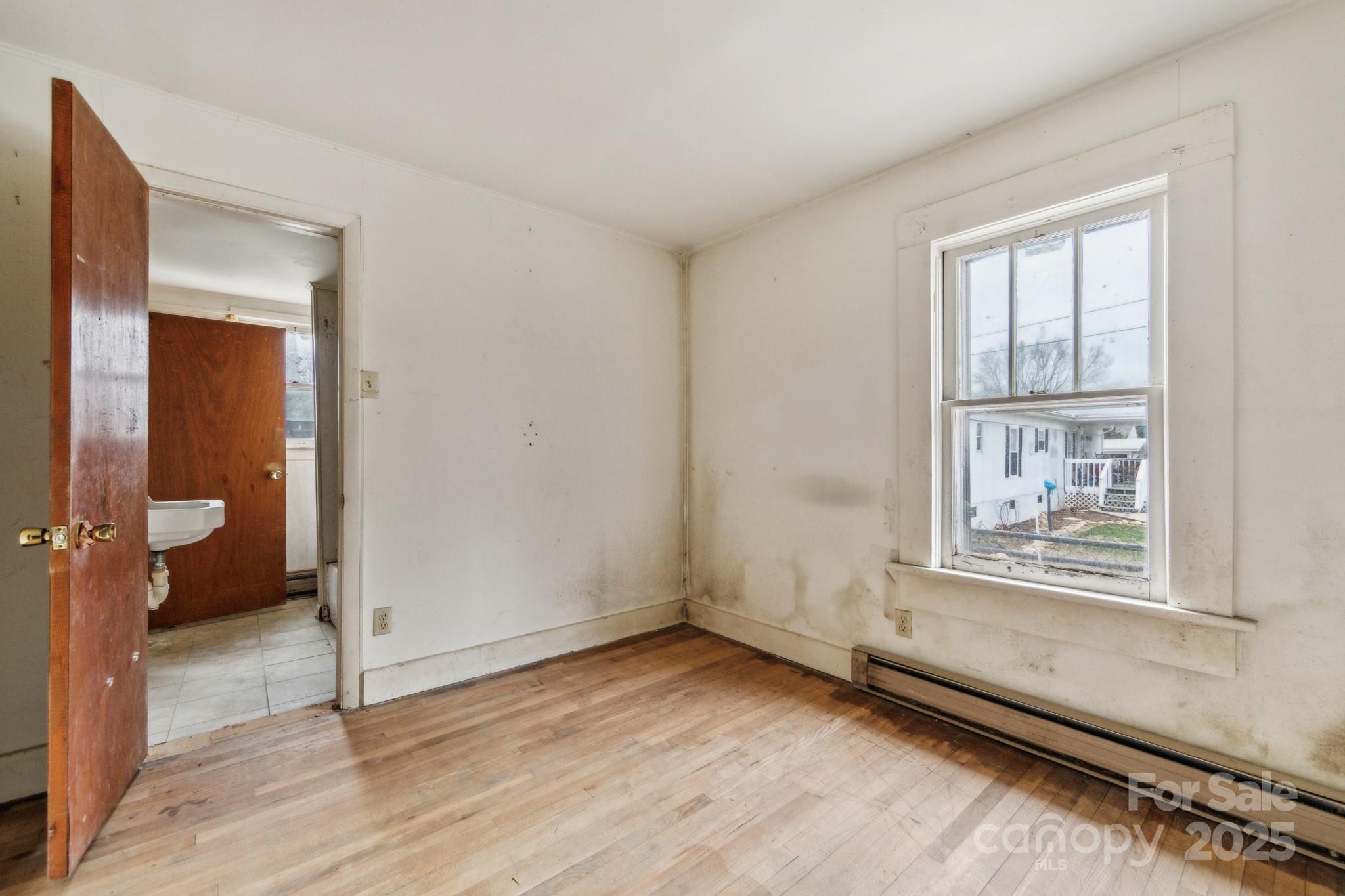 364 Browning Road Waynesville, NC 28786 - Photo 28 of 29 an empty room with a window and wooden floor