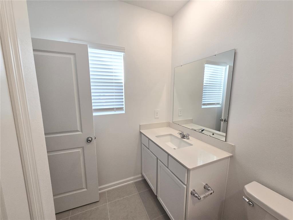 2376 Rider Rain Lane Apopka, FL 32703 - Photo 22 of 27 a bathroom with a sink a mirror and a window