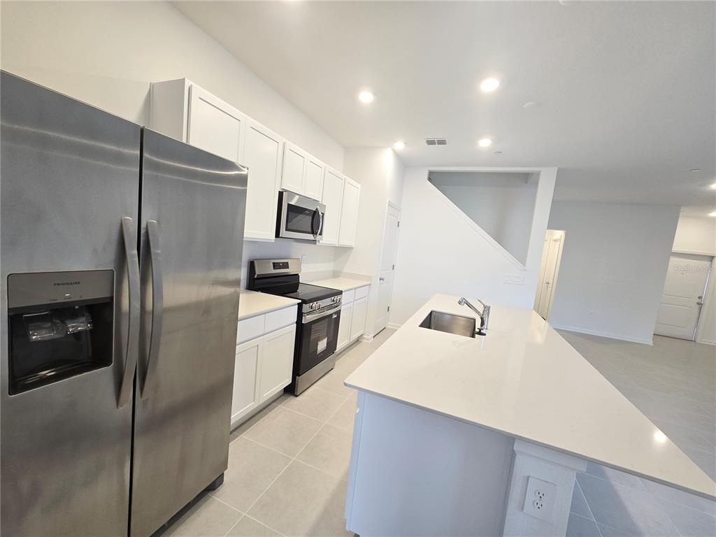 2376 Rider Rain Lane Apopka, FL 32703 - Photo 5 of 27 a kitchen with stainless steel appliances a refrigerator and a sink