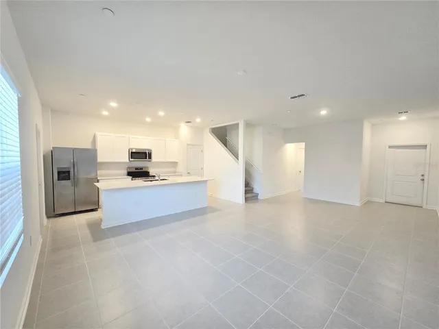 a large kitchen with a refrigerator and a stove top oven