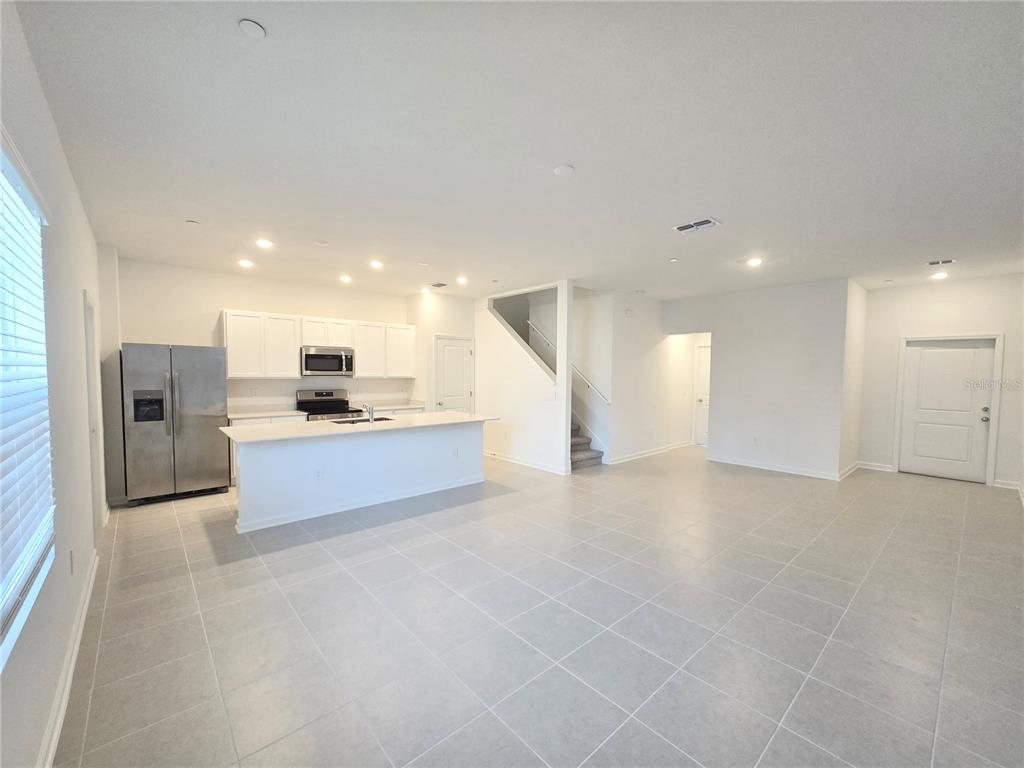 2376 Rider Rain Lane Apopka, FL 32703 - Photo 6 of 27 a large kitchen with a refrigerator and a stove top oven