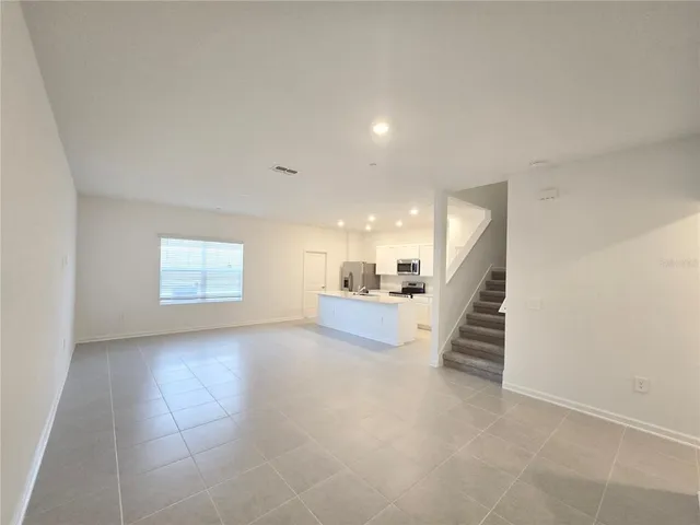 an empty room with windows and stairs