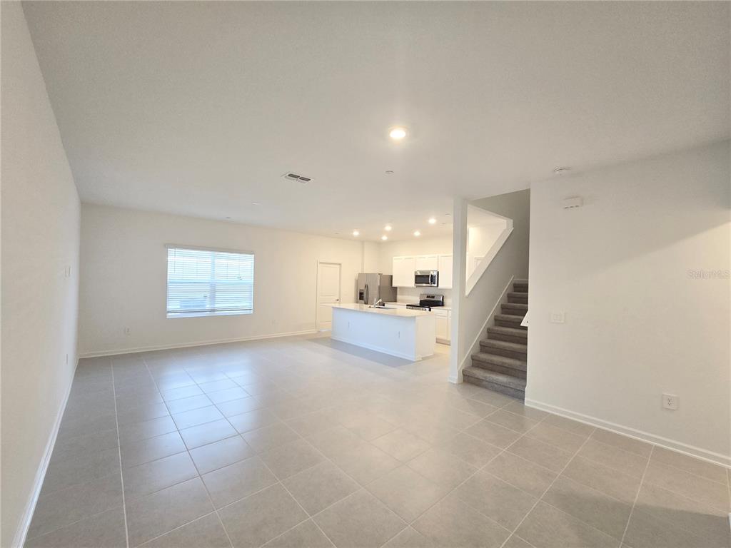 2376 Rider Rain Lane Apopka, FL 32703 - Photo 7 of 27 an empty room with windows and stairs