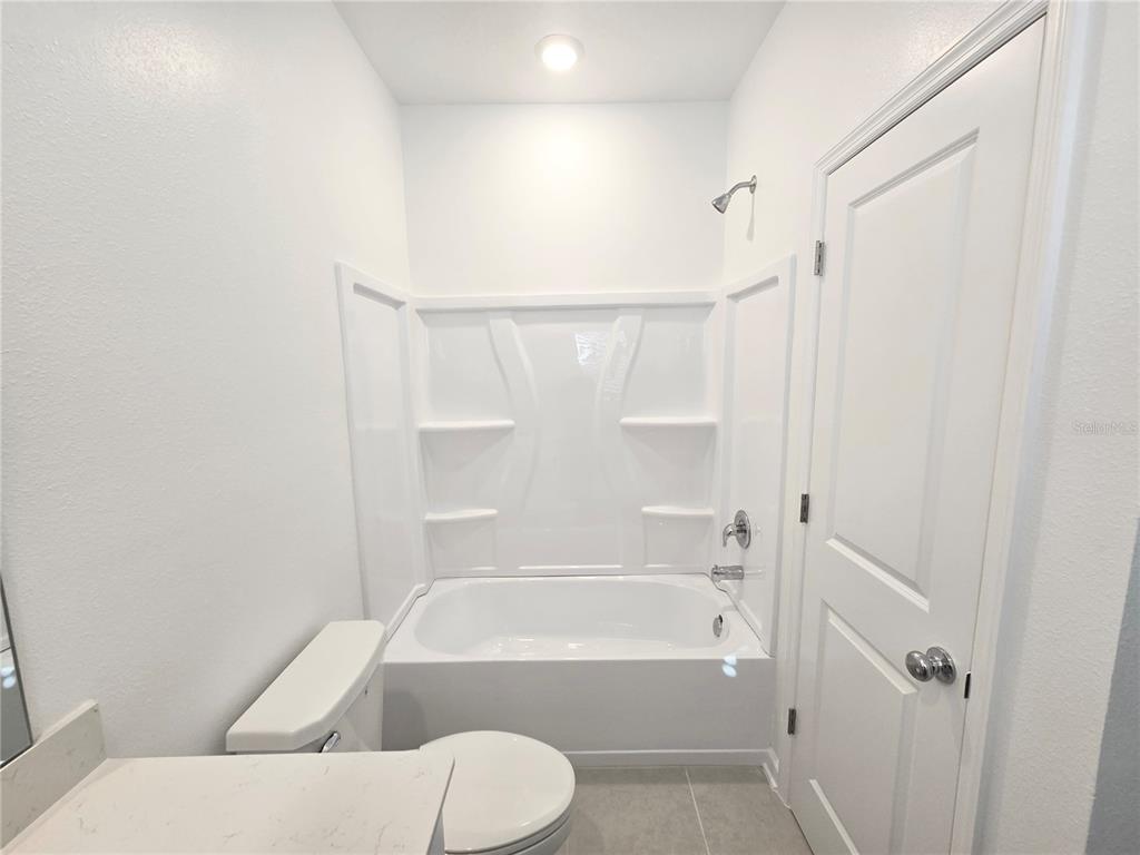 2376 Rider Rain Lane Apopka, FL 32703 - Photo 9 of 27 a bathroom with a toilet and a bathtub