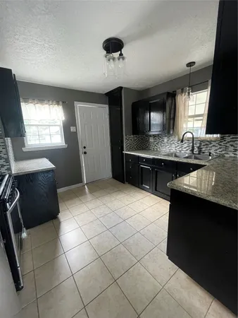 a kitchen with a sink a stove and cabinets