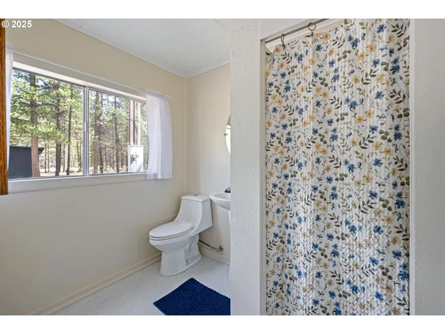 a bathroom with a toilet and a shower curtain
