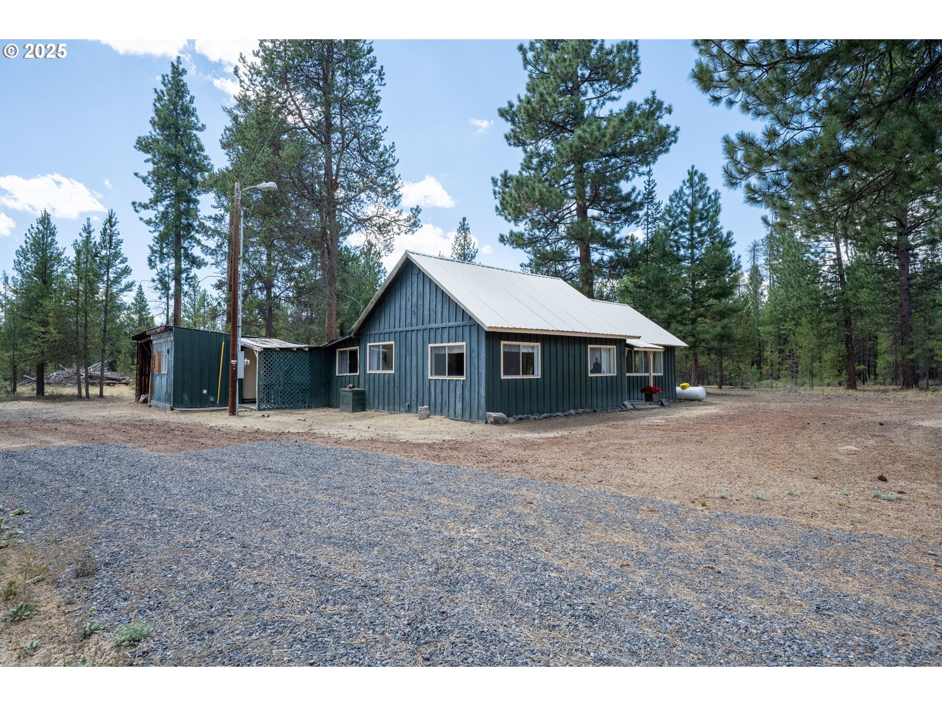 652 Chapman Street Gilchrist, OR 97737 - Photo 27 of 29 a front view of a house with a yard and trees