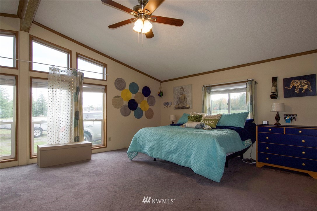 411 Spencer Road Sequim, WA 98382 - Photo 22 of 40 a spacious bedroom with a bed and a large window