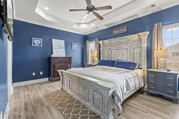 a bedroom with a large bed and a chandelier
