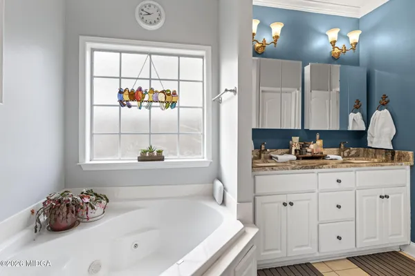 a bathroom with a tub sink and mirror