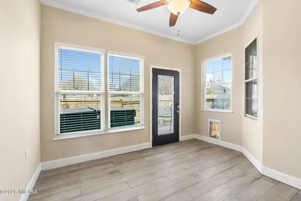 a view of an empty room with a window and wooden floor