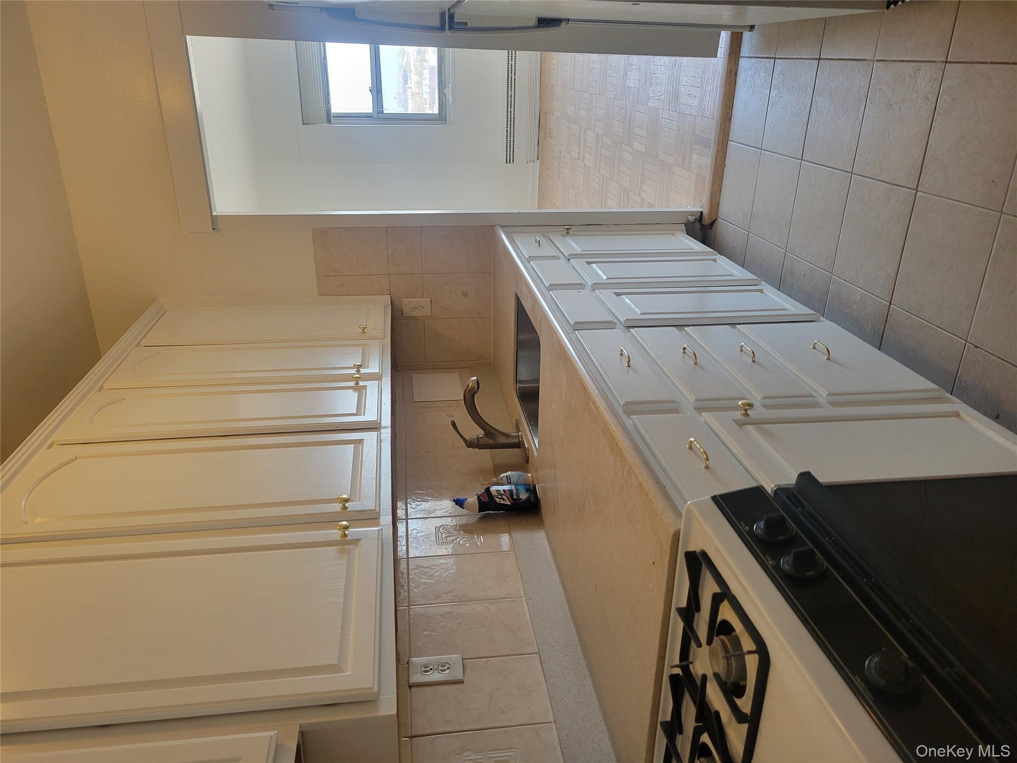 7 Fordham Hill Ovl, Unit 16C Bronx, NY 10468 - Photo 7 of 17 a kitchen with cabinets and appliances