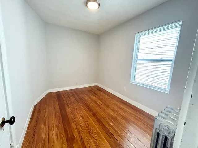 a view of a room with wooden floor and window