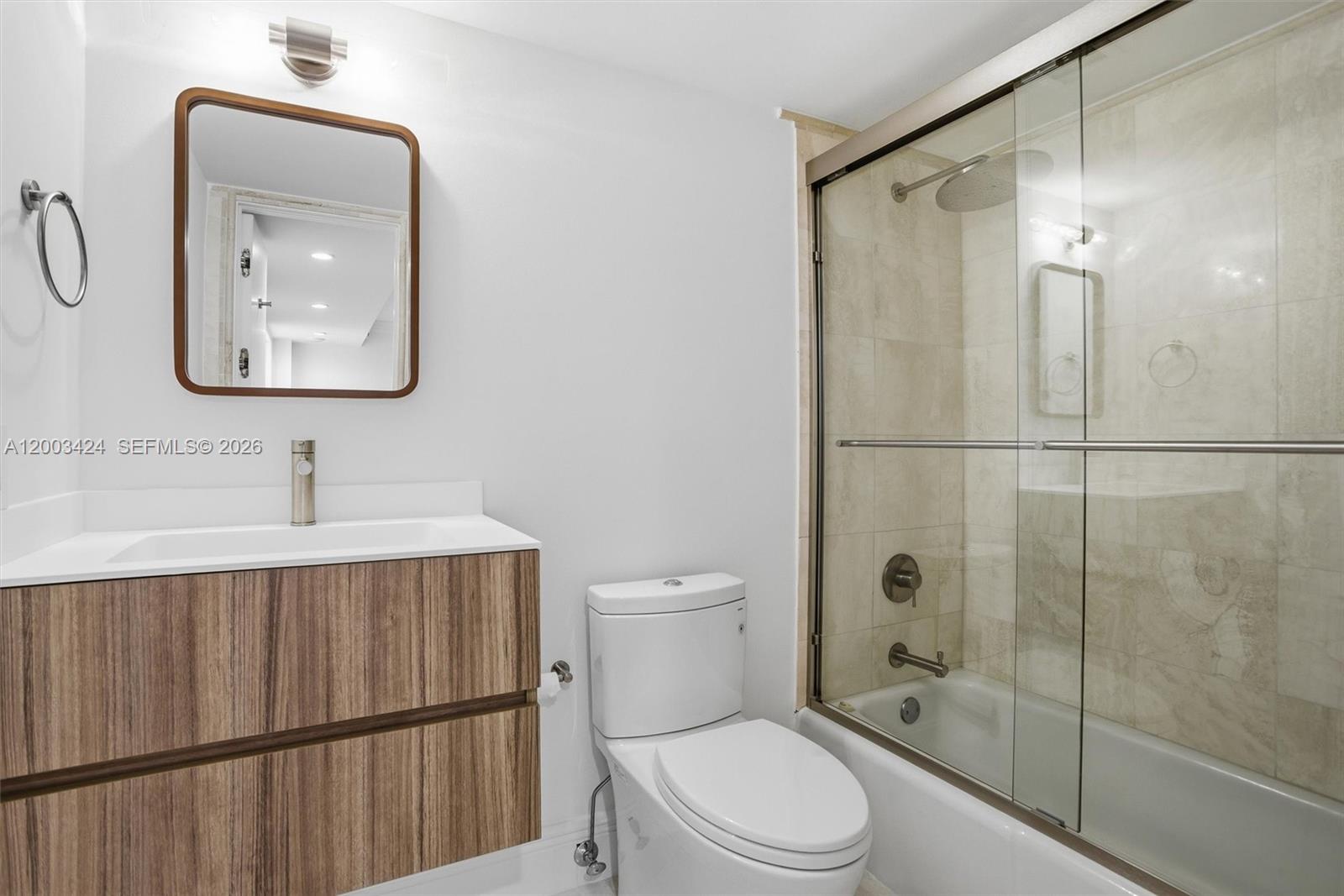 600 Grapetree Drive, Unit 4BS Key Biscayne, FL 33149 - Photo 34 of 75 a bathroom with a toilet a sink a glass door a shower and a mirror