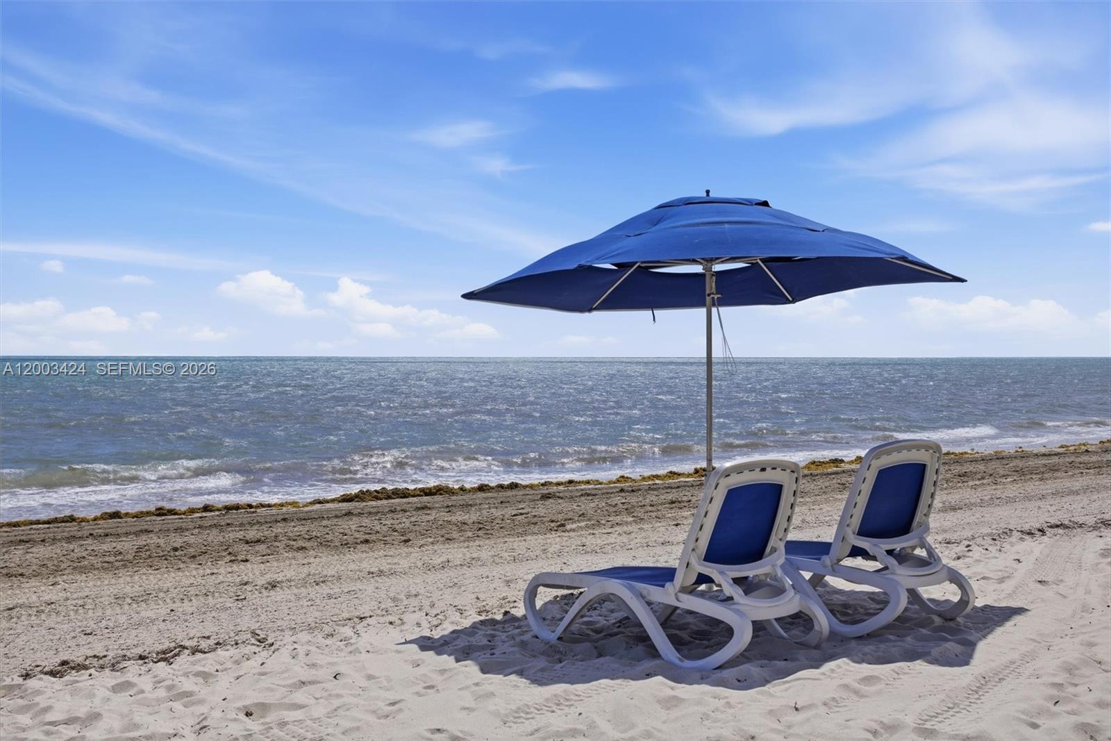 600 Grapetree Drive, Unit 4BS Key Biscayne, FL 33149 - Photo 50 of 75 a view of a lake with a table and chairs under an umbrella