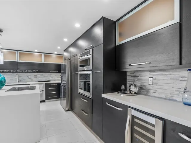 a kitchen with stainless steel appliances and chandelier