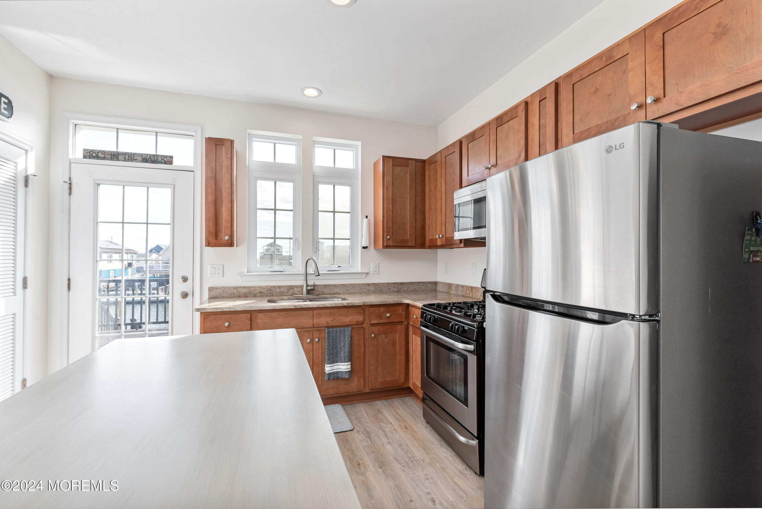 145 Flamingo Road Tuckerton, NJ 08087 - Photo 14 of 43 a kitchen with stainless steel appliances granite countertop a refrigerator a sink a stove and white cabinets with wooden floor