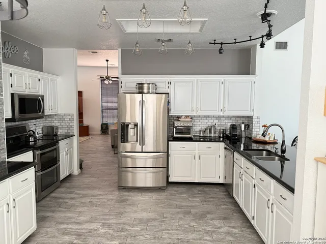 a kitchen with stainless steel appliances a refrigerator sink and stove