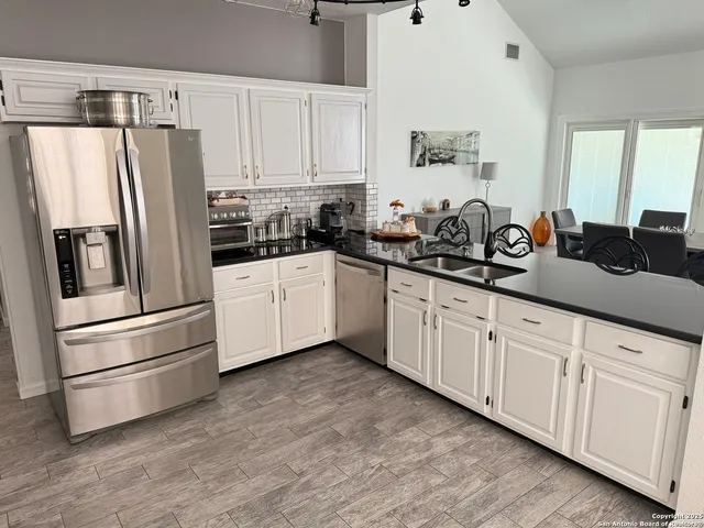 a kitchen with stainless steel appliances a refrigerator sink and cabinets