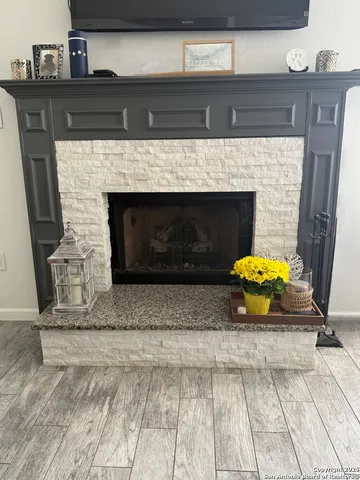 a bedroom with fireplace and a wooden floor