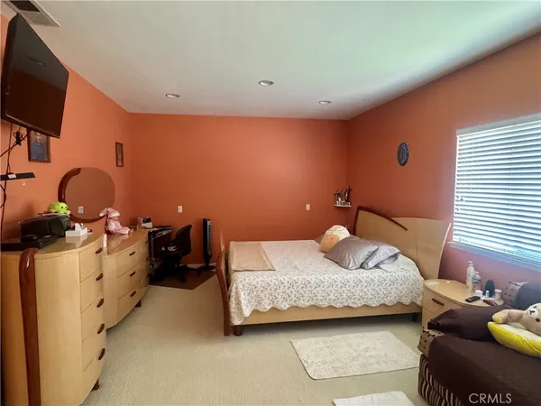 a bedroom with bed and a flat screen tv