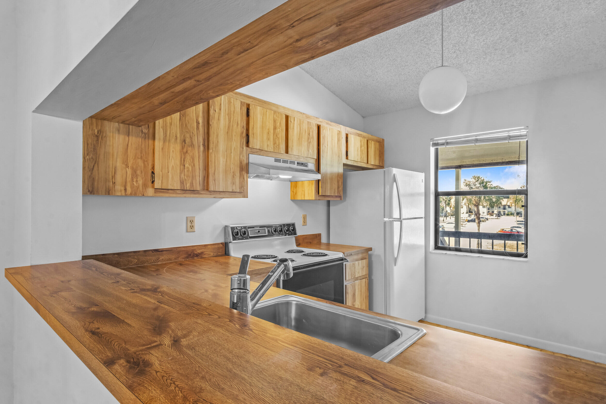 22076 Palms Way, Unit 203 Boca Raton, FL 33433 - Photo 13 of 25 a kitchen with stainless steel appliances granite countertop a refrigerator sink and cabinets