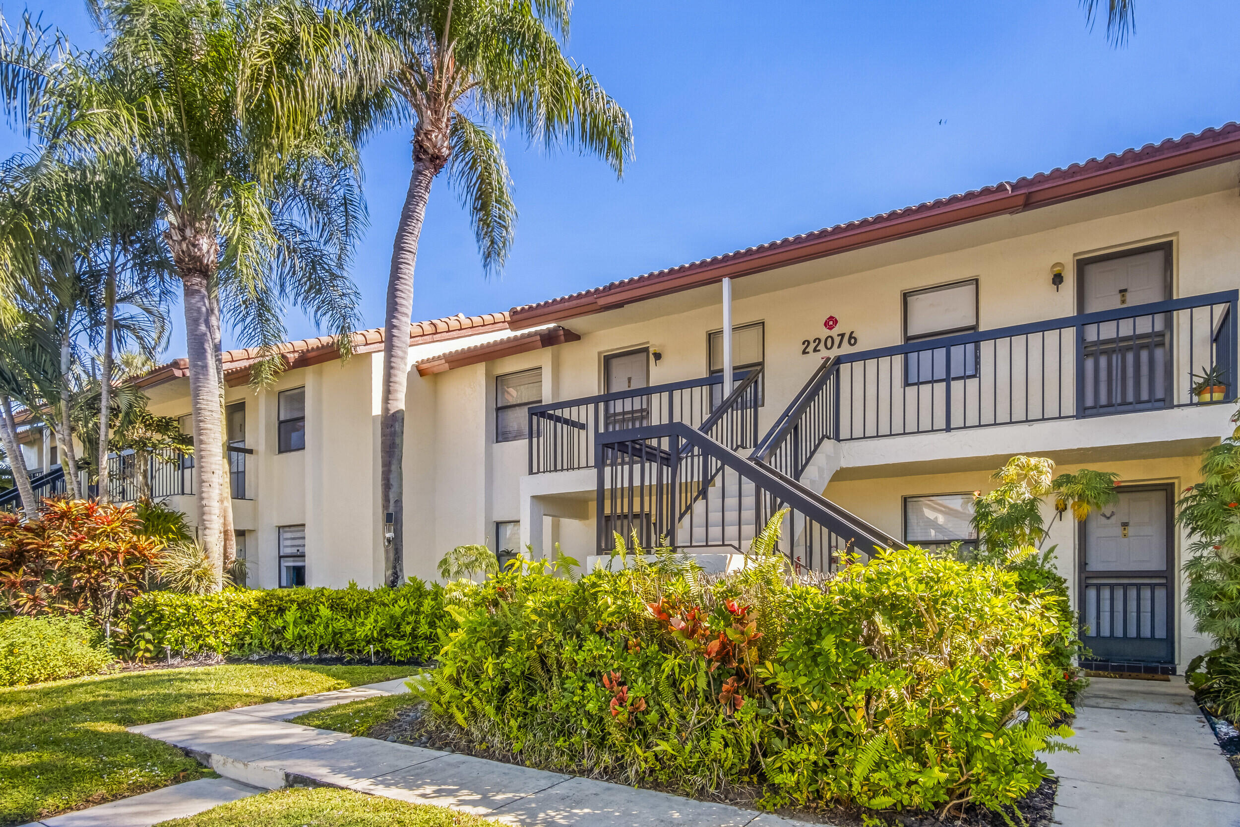 22076 Palms Way, Unit 203 Boca Raton, FL 33433 - Photo 2 of 25 a front view of a building with garden