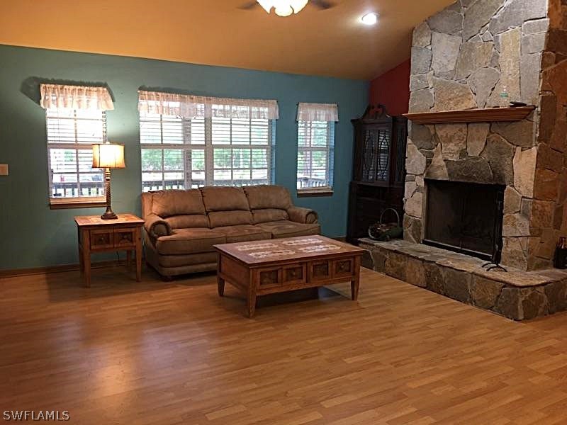 12931 Shawnee Road Fort Myers, FL 33913 - Photo 3 of 19 a living room with furniture a flat screen tv and a fireplace