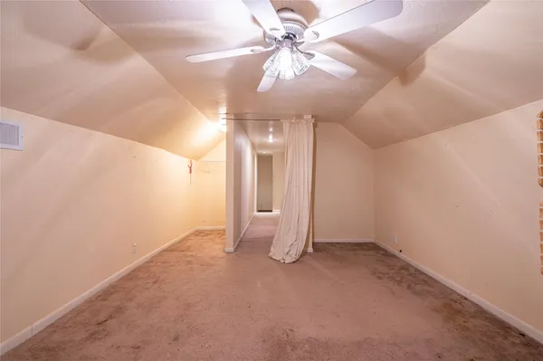 en empty room with windows and fan