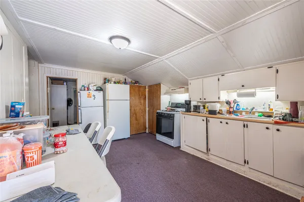 a kitchen with refrigerator and white cabinets
