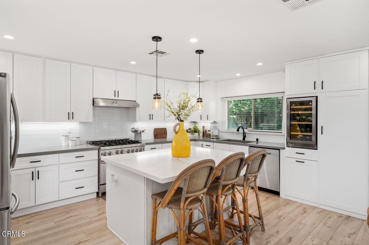 3875 Cartwright Street Pasadena, CA 91107 - Photo 8 of 25 a kitchen with stainless steel appliances granite countertop a stove a refrigerator a kitchen island a stove and a wooden floors
