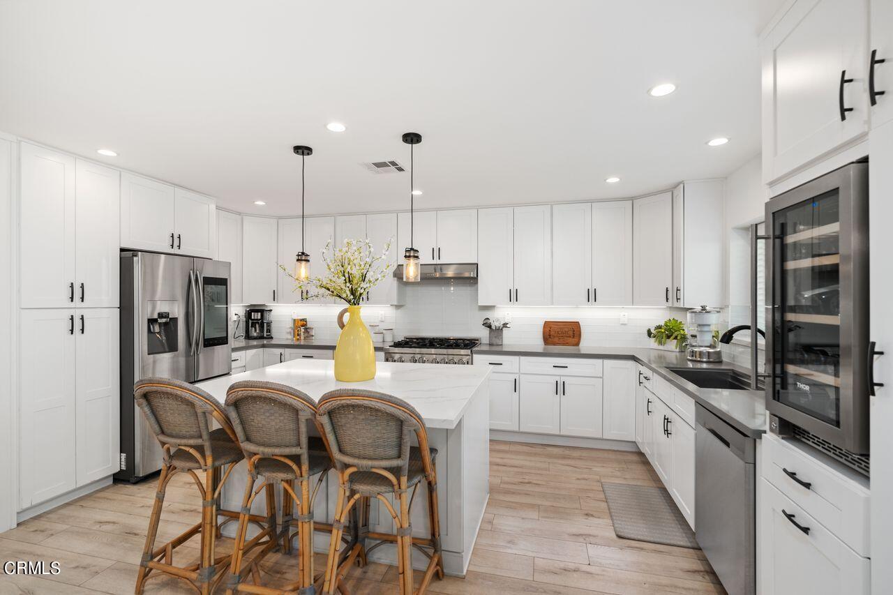 3875 Cartwright Street Pasadena, CA 91107 - Photo 9 of 25 a kitchen with refrigerator a stove a sink and chairs