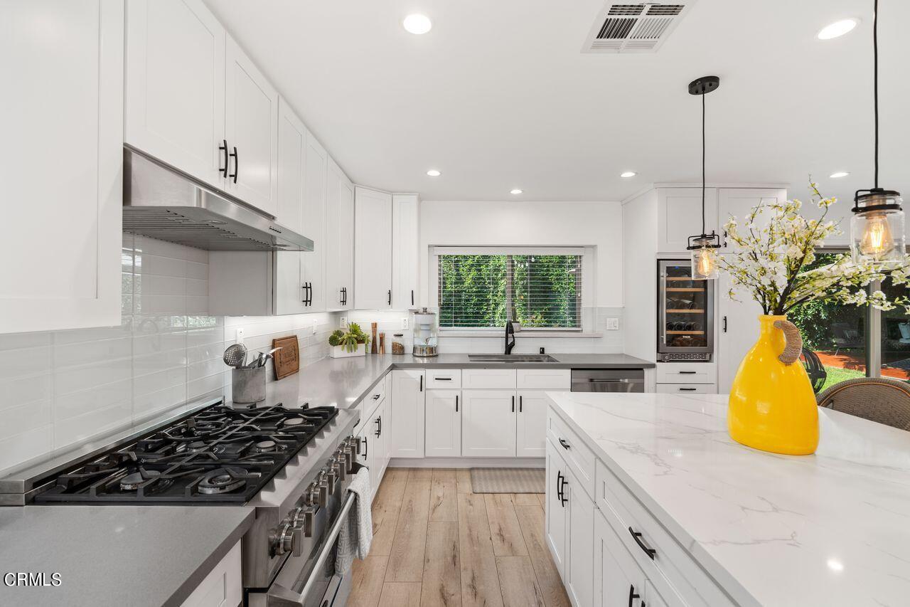3875 Cartwright Street Pasadena, CA 91107 - Photo 10 of 25 a kitchen with stainless steel appliances a sink a counter top space cabinets and a window