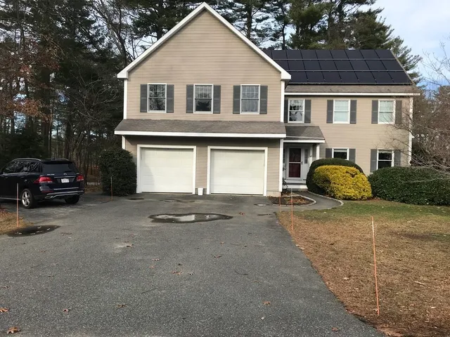 a front view of a house with cars parked