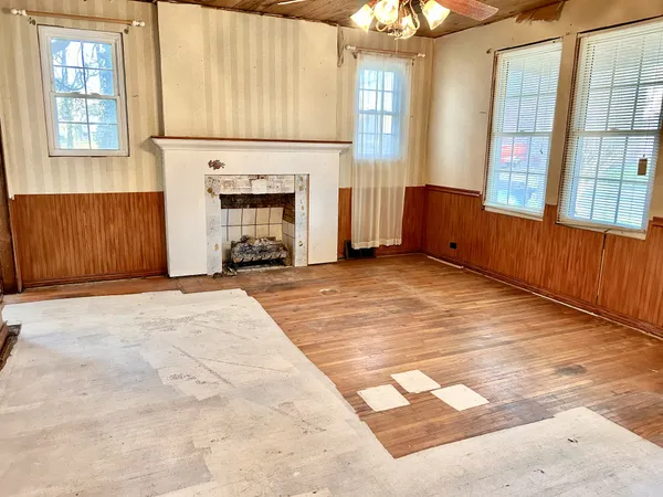 an empty room with windows and fireplace