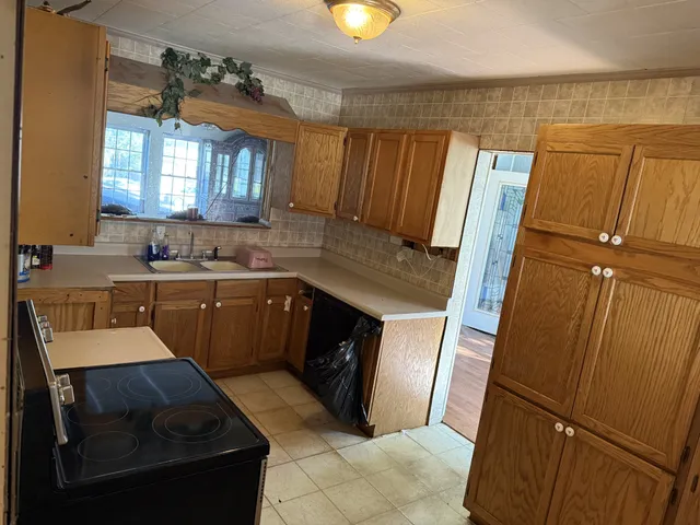 a kitchen with a sink refrigerator and window
