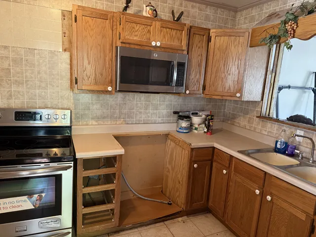 a kitchen with stainless steel appliances a stove a microwave and sink